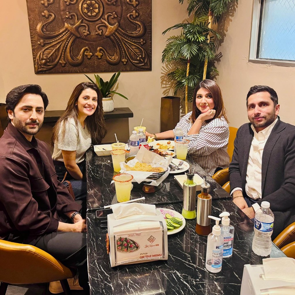 Friends gathered around the table with BBQ platters, lemonade, and BK Khan's signature menu